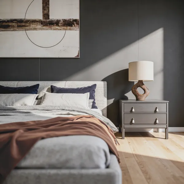 3D rendering detail of a bed with navy velvet pillows and a sculptural wood lamp on a gray nightstand